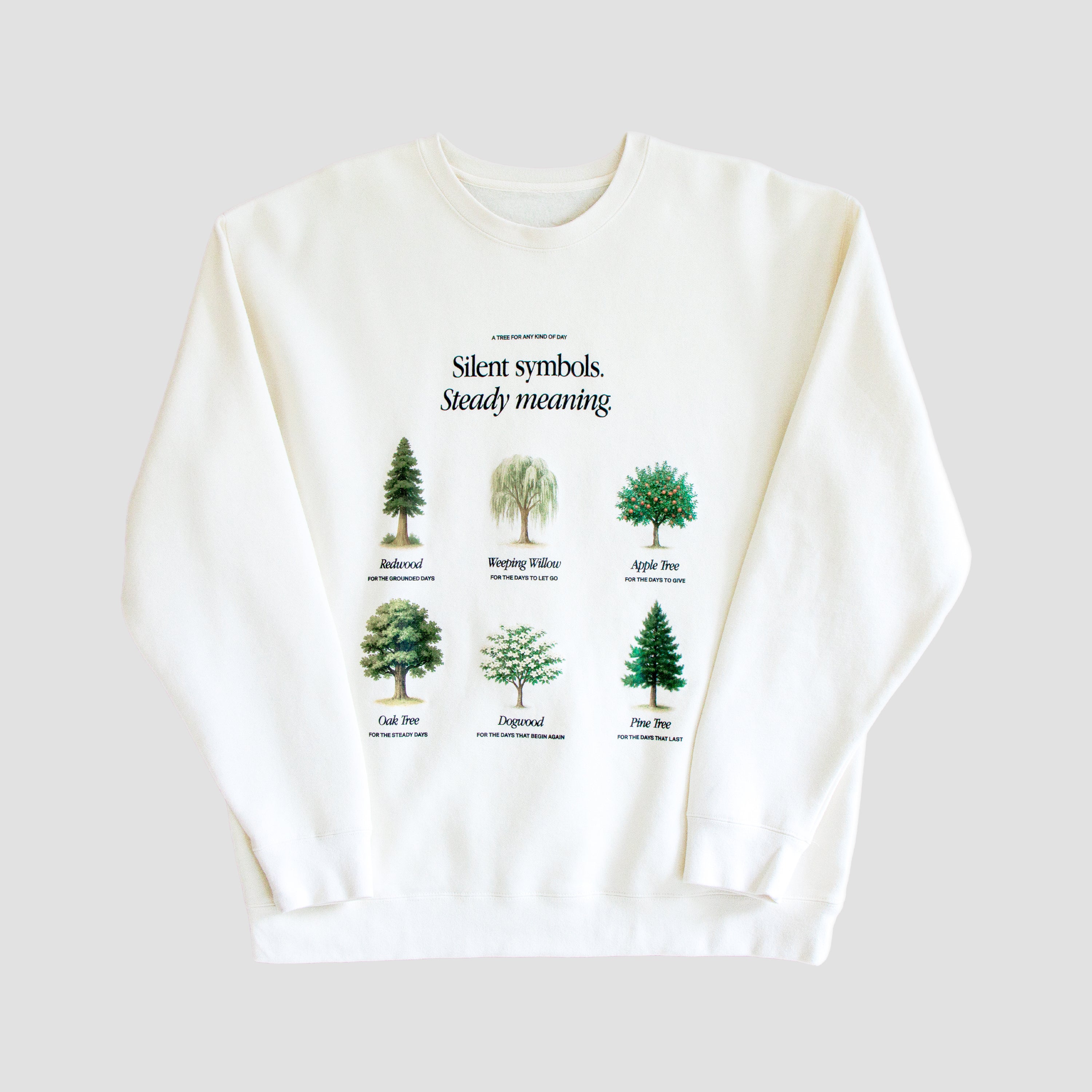 White sweatshirt with tree illustrations and text on a white background